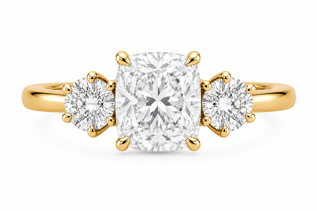 Adelaide 14K yellow gold three-stone engagement ring with a cushion center and round lab grown side diamonds.