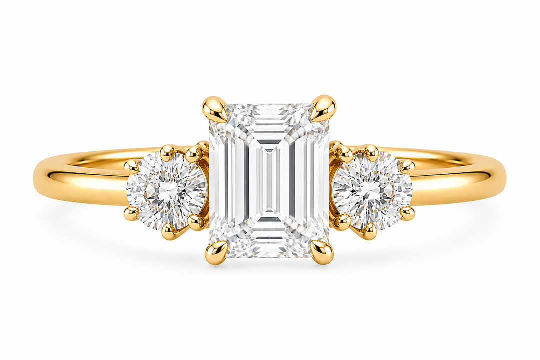 Adelaide 14K yellow gold engagement ring with emerald cut center and round side diamonds.
