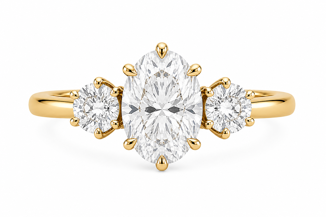 Adelaide three-stone engagement ring with oval center diamond, round side stones, and 14K yellow gold band.