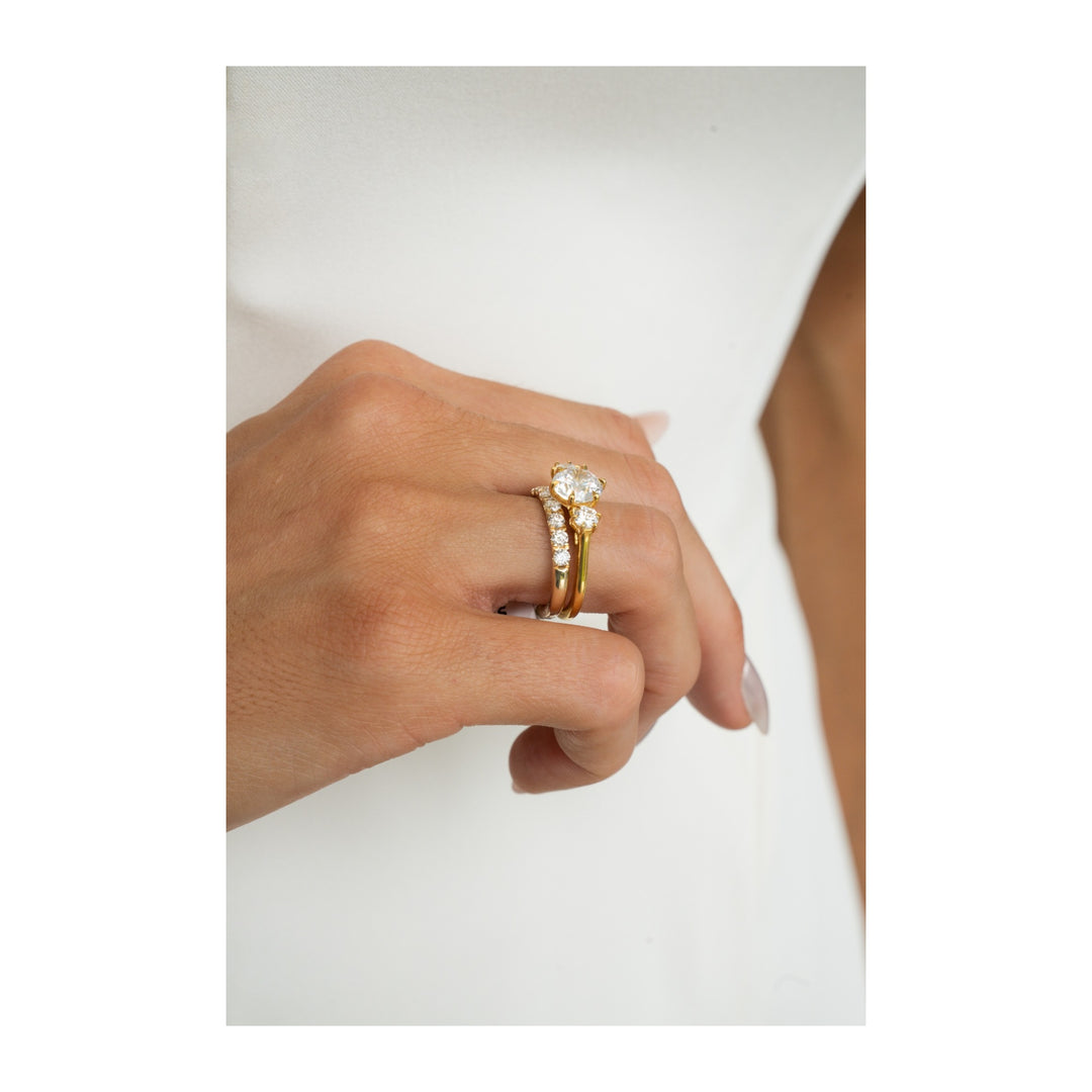 Adelaide 14K yellow gold three-stone engagement ring with round side diamonds and a 2 CT center diamond.