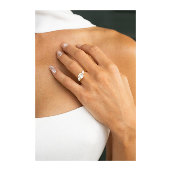 Adelaide 14K yellow gold three-stone engagement ring with a large center diamond and two round side diamonds.
