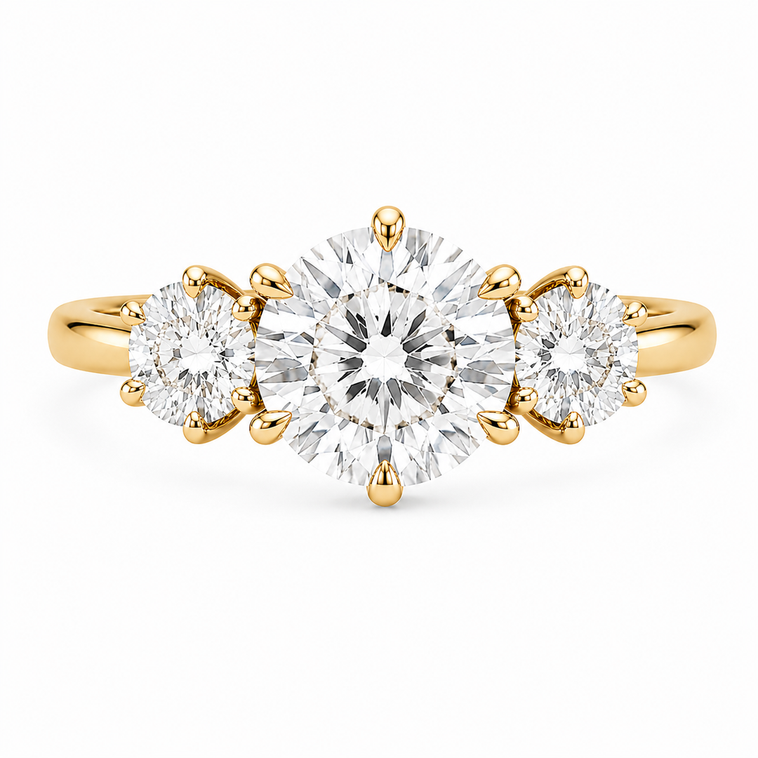 Adelaide 14K yellow gold three-stone engagement ring with a large round center diamond and two smaller round side diamonds.
