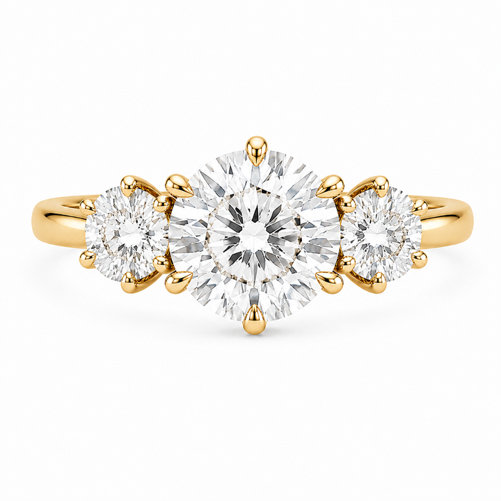 Adelaide 14K yellow gold three-stone engagement ring with a large round center diamond and two smaller round side diamonds.