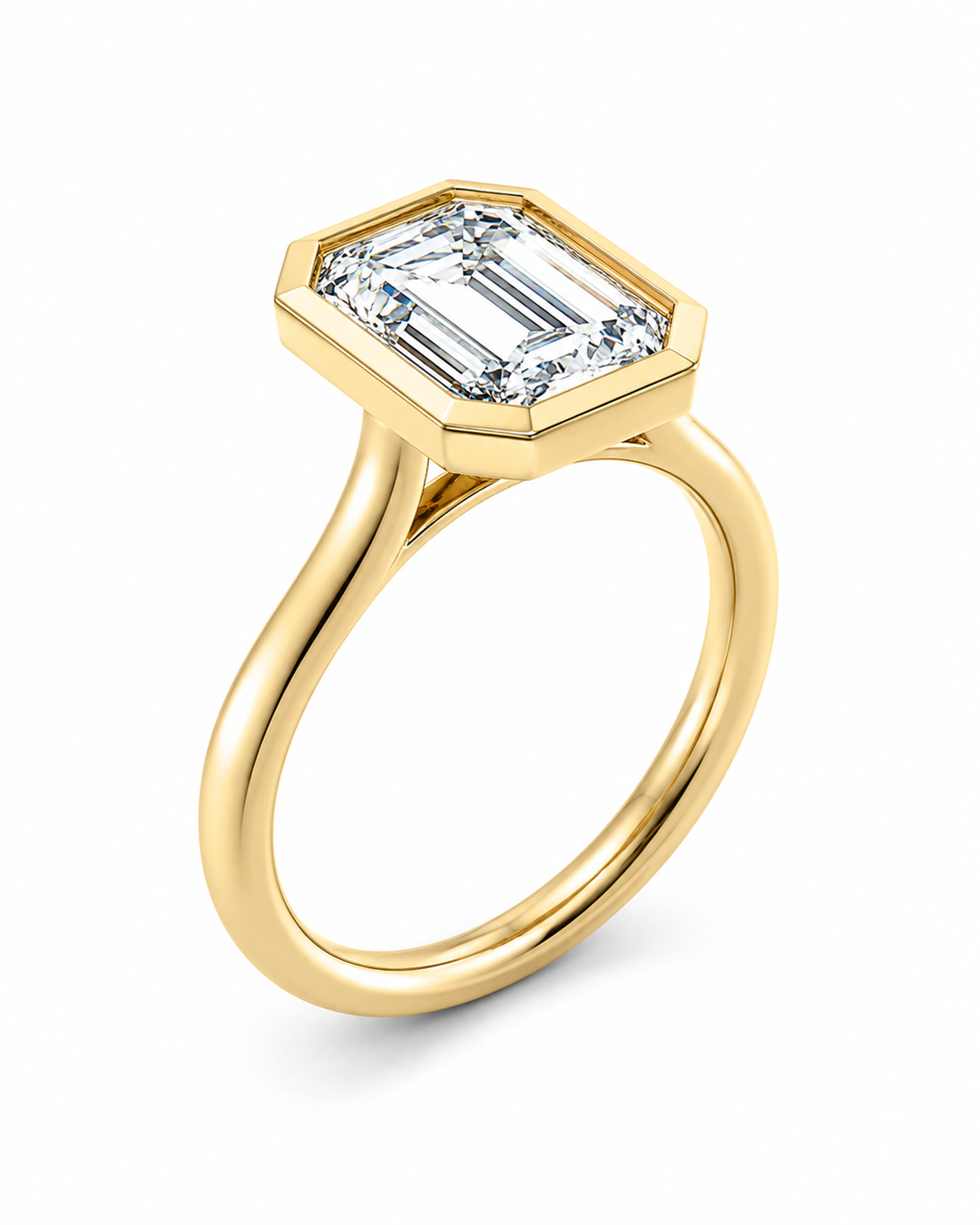 Celine 14K yellow gold engagement ring with a bezel-set emerald cut diamond.