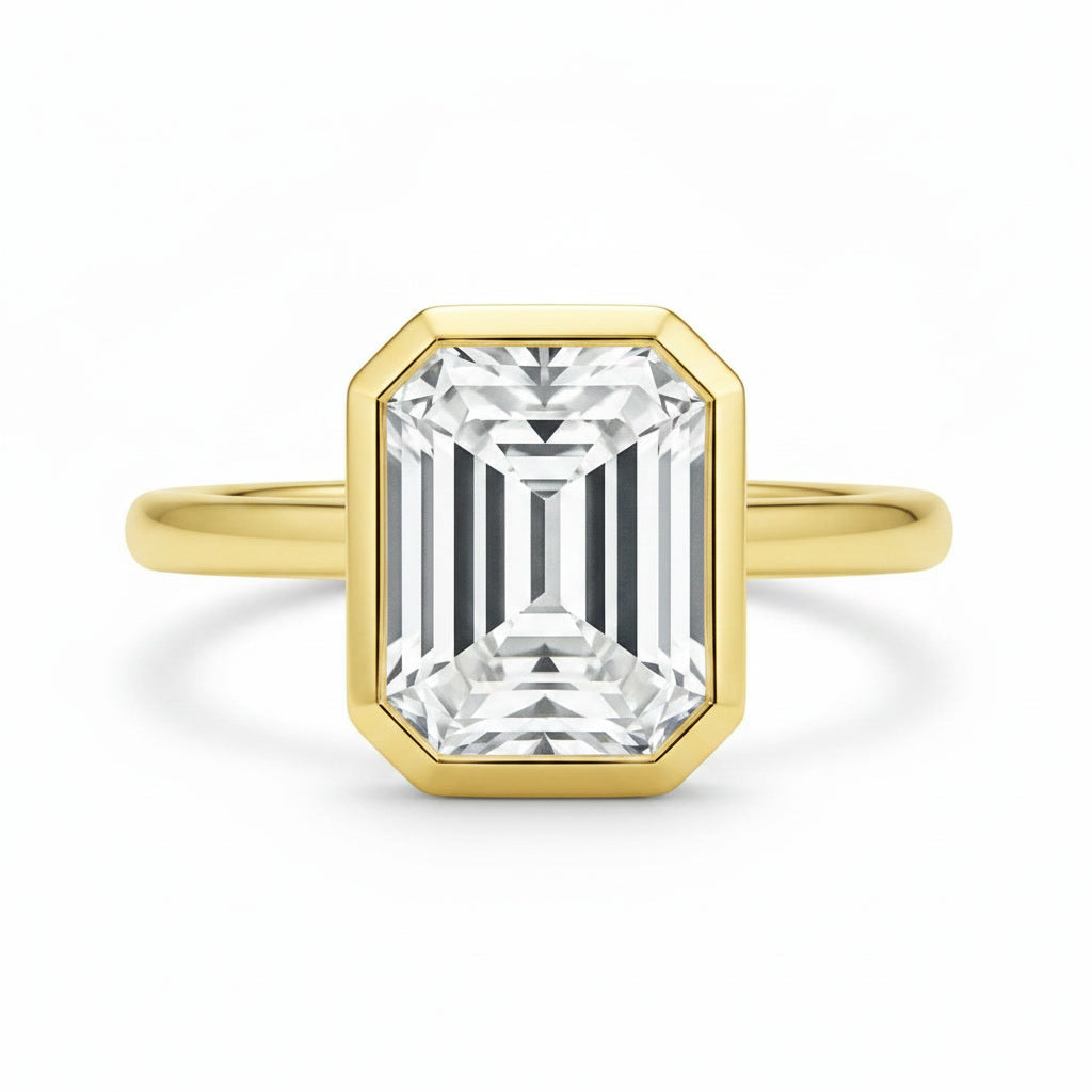Celine Signature Engagement ring with an emerald-cut diamond in a 14K yellow gold bezel setting.