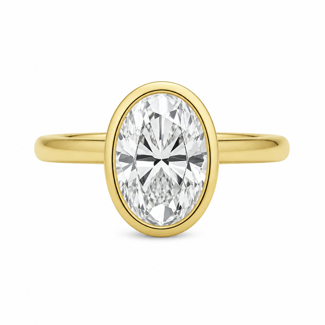 Celine 14K yellow gold engagement ring with a modern bezel-set oval diamond.