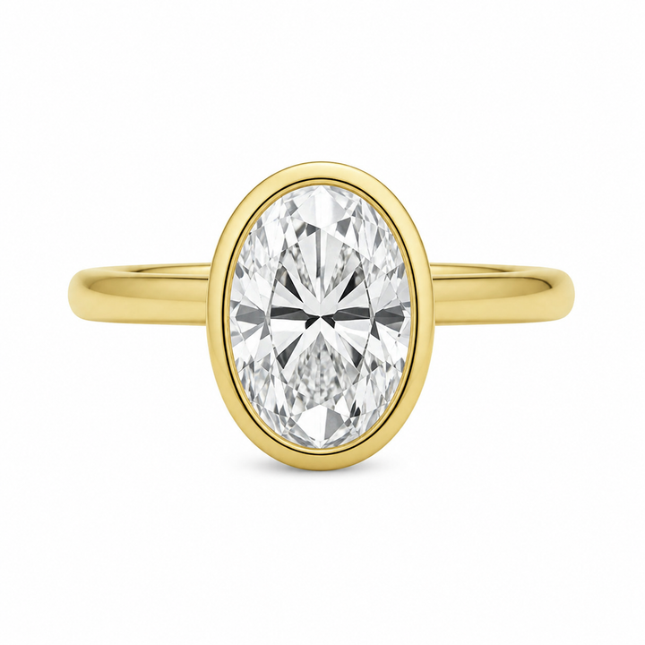Celine 14K yellow gold engagement ring with a modern bezel-set oval diamond.