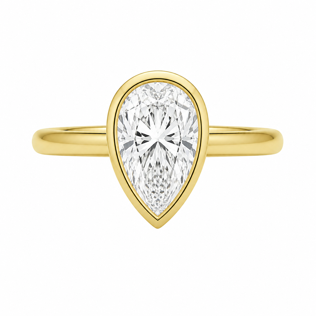 Celine 14K yellow gold engagement ring with a pear-shaped bezel-set diamond.