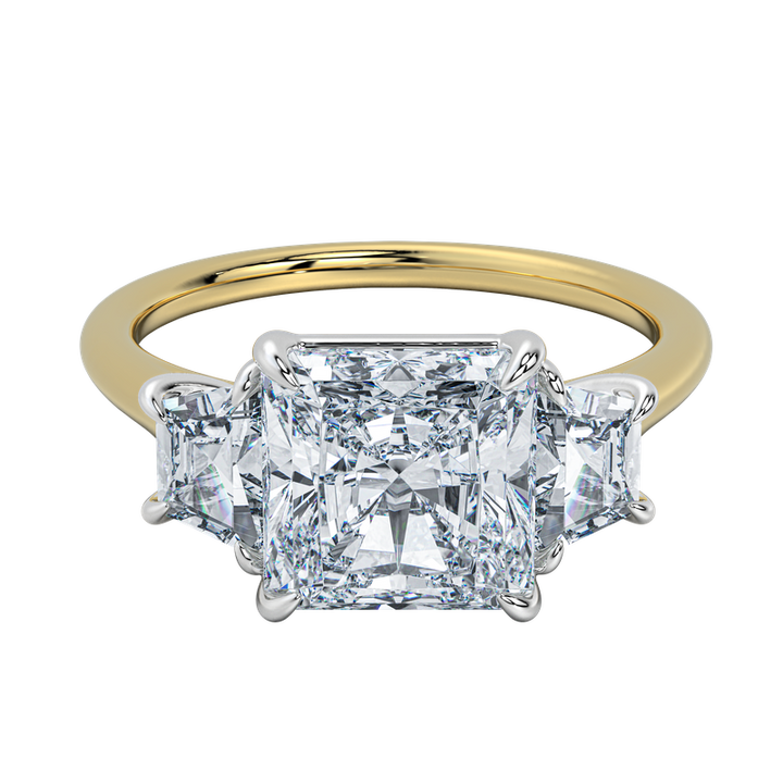 Charlotte engagement ring: gold band, emerald cut center diamond, trapezoid side stones.