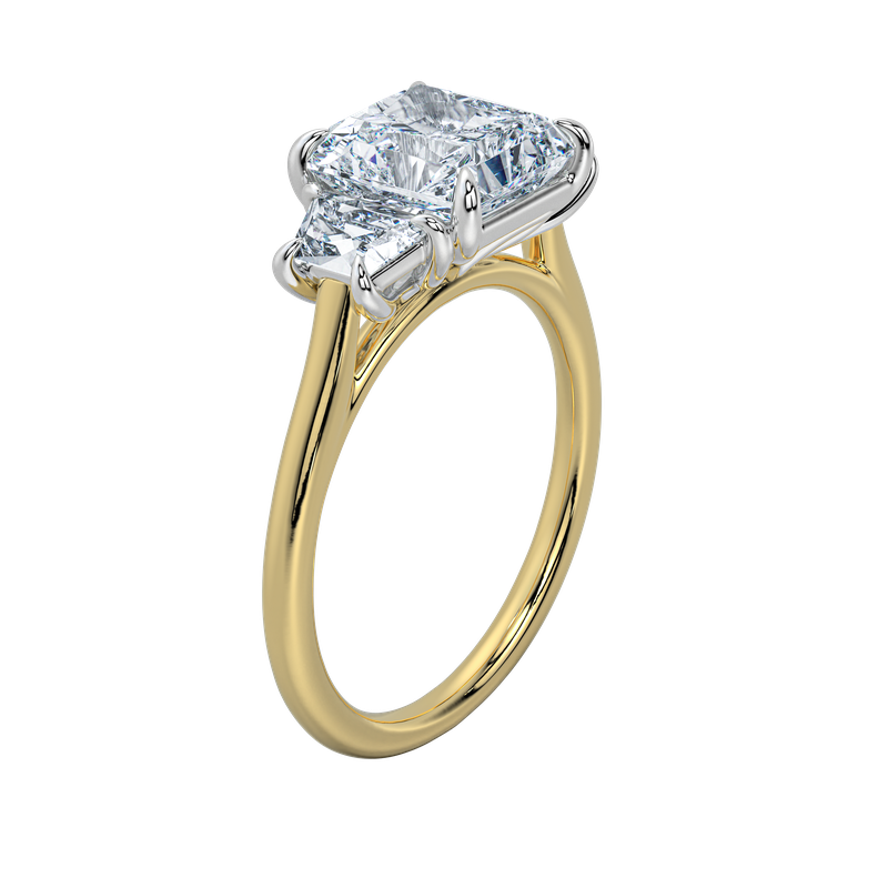 Charlotte engagement ring with an emerald cut center stone and trapezoid side stones on a yellow gold band.