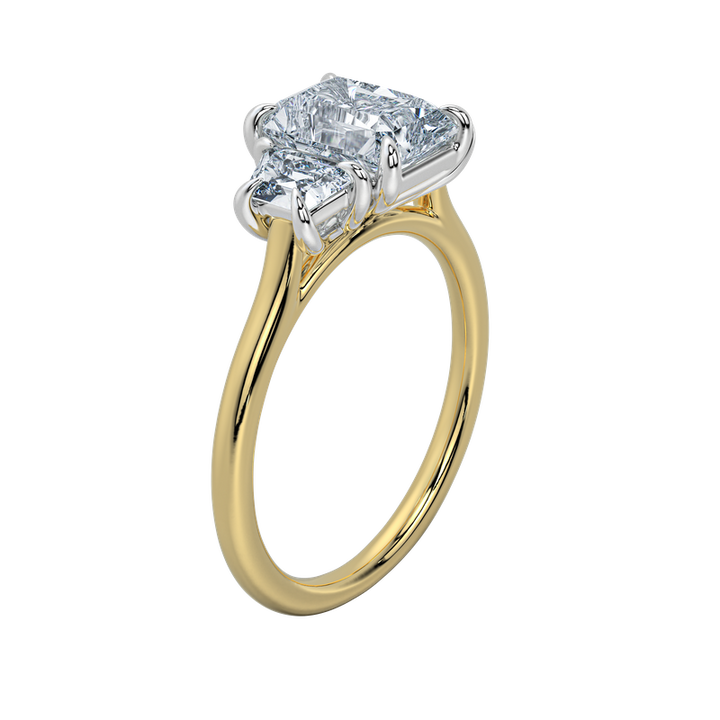Charlotte engagement ring: gold band, emerald cut center stone, trapezoid side stones.