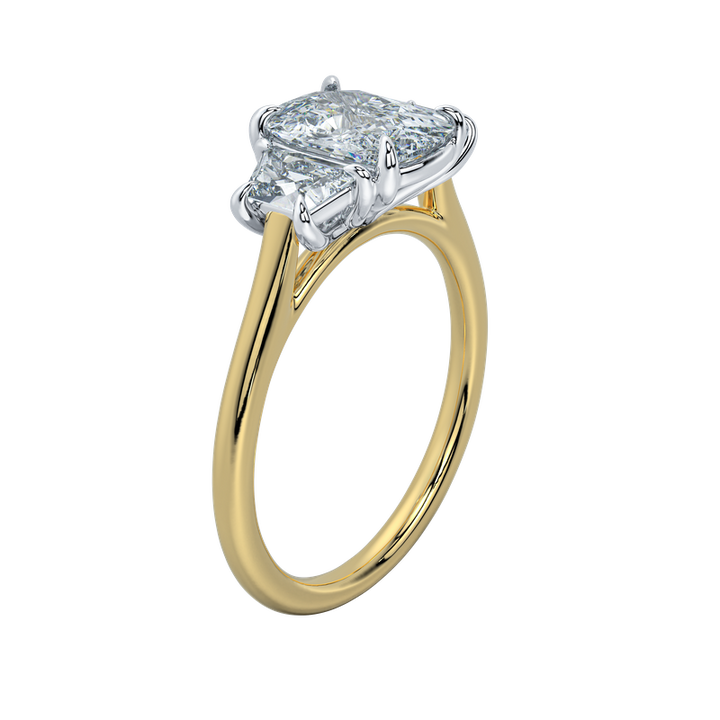 Gold engagement ring with emerald cut center diamond and trapezoid side stones.