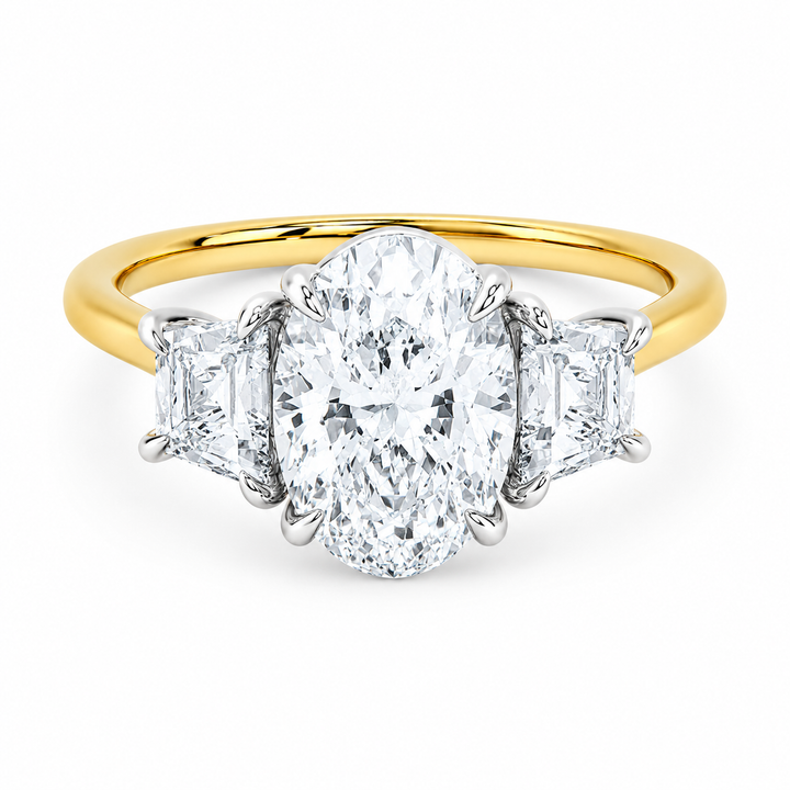 Charlotte three-stone engagement ring with oval center diamond, trapezoid side stones, 14K yellow and white gold.