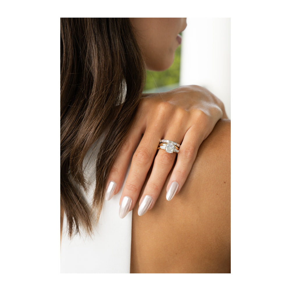 Colette three-stone engagement ring with a 2 CT diamond and tapered baguette side stones on a woman's hand.