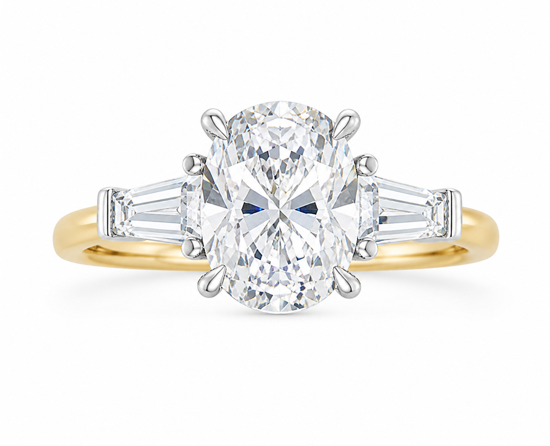 Colette three-stone engagement ring with an oval diamond, tapered baguette side stones, and a two-tone 14K yellow gold band.