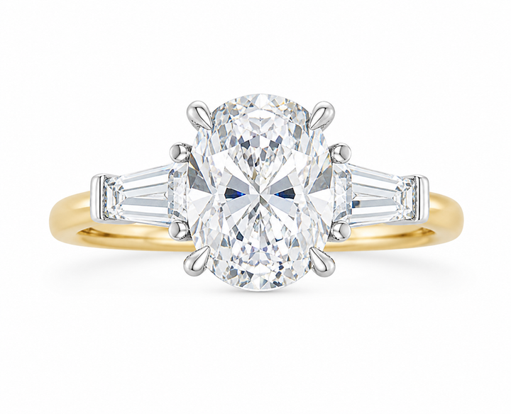 Colette three-stone engagement ring with an oval diamond, tapered baguette side stones, and a two-tone 14K yellow gold band.