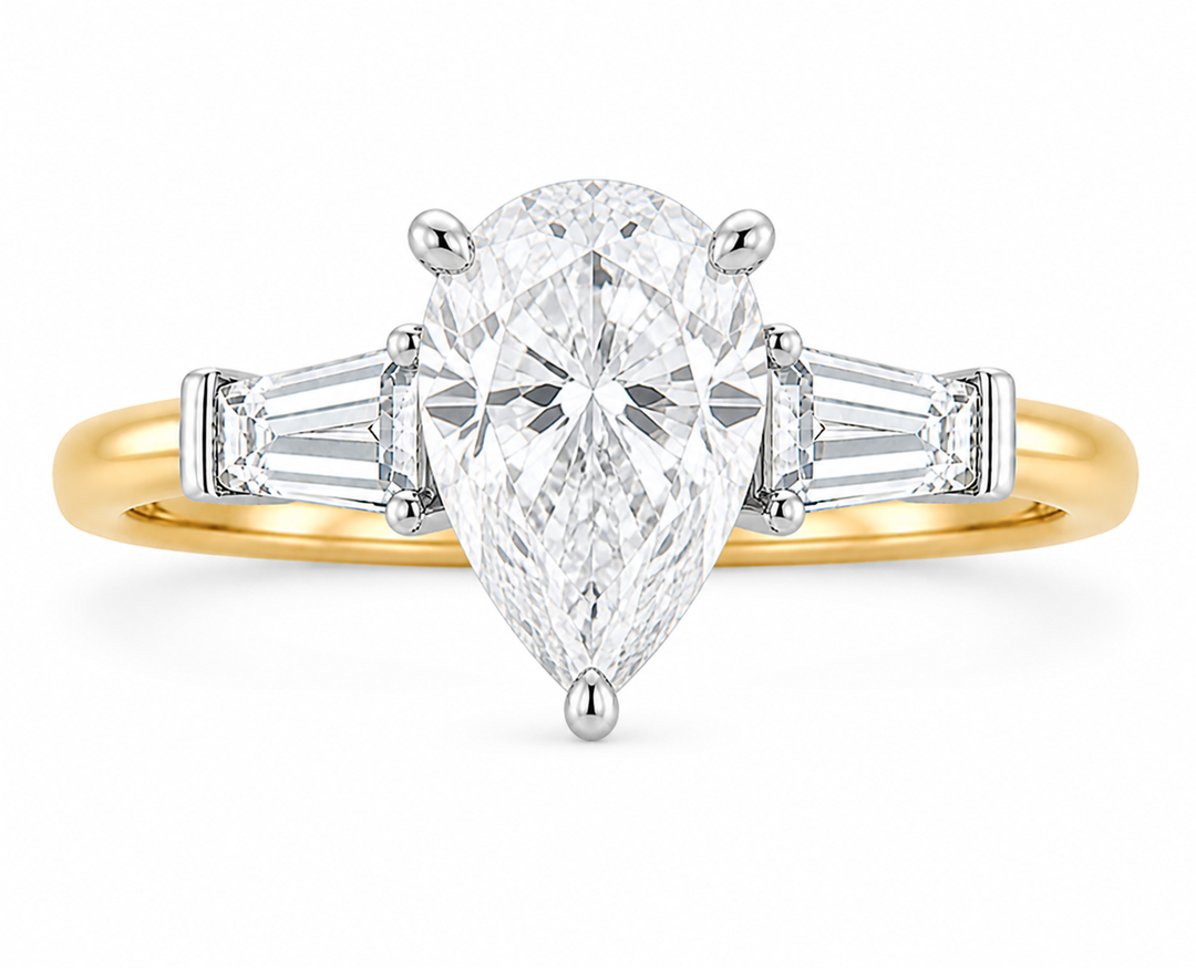 Colette Signature Engagement Style: 14K yellow gold band with white gold prongs, pear-shaped center diamond, and tapered baguette side stones.