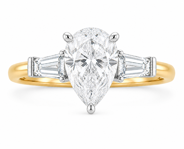Colette Signature Engagement Style: 14K yellow gold band with white gold prongs, pear-shaped center diamond, and tapered baguette side stones.