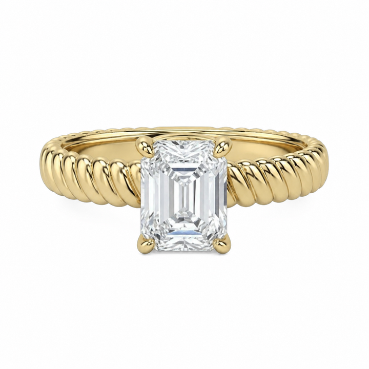 Jenn Signature engagement ring with a solitaire emerald cut diamond and 14K yellow gold rope band.