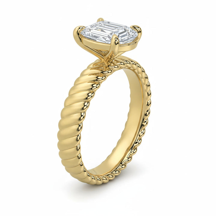 Jenn Signature engagement ring with a solitaire emerald cut diamond and a 14K yellow gold rope band.